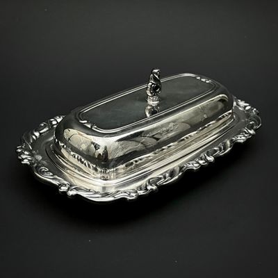 un plat ancien en argent recouvert d'un couvercle en verre sur fond noir