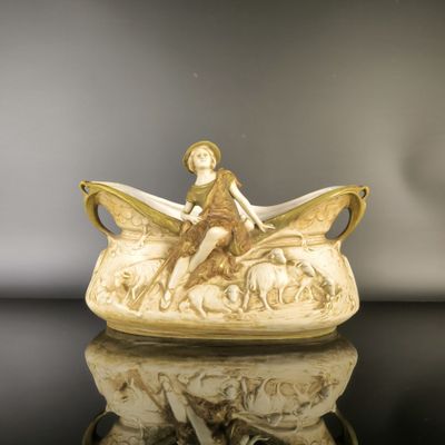 a figurine of a woman sitting on top of a boat
