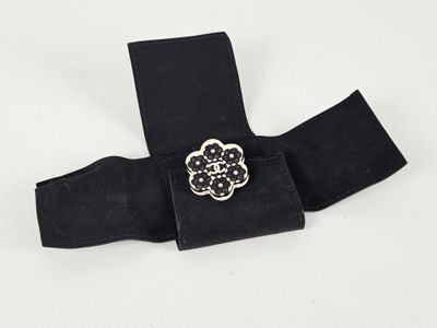 une image représentant une ceinture noire ornée d'une boucle en forme de fleur