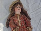 a doll that is laying down on a white sheet