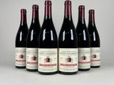 six bouteilles de vin sont alignées sur une table