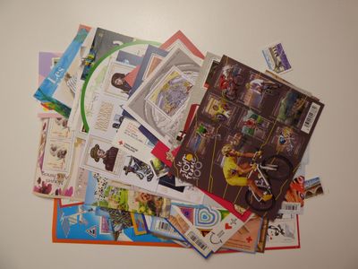 une pile de cartes postales posée sur une table sur laquelle se trouve une horloge