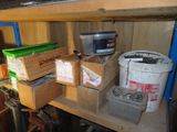 a shelf with several boxes and a bucket on it