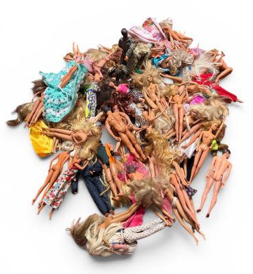 a pile of barbie dolls on a white surface