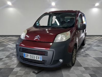 une petite camionnette rouge garée sur un sol à damier