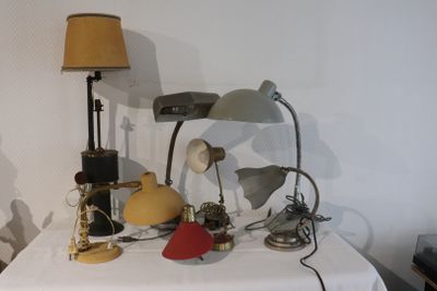 une table sur laquelle se trouvent une lampe, un abat-jour, une lampe et d'autres objets