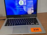 un ordinateur portable Dell posé sur un bureau, avec une étiquette de prix sur l'écran