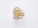 une bague sertie d'un diamant jaune et blanc sur fond blanc