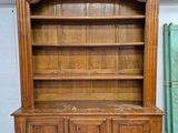 a large wooden bookcase with a shelf on top of it
