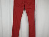 a pair of red jeans hanging on a white curtain