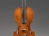 un vieux violon posé sur un chevalet, sur fond gris