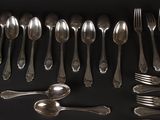 a lot of spoons and forks on the table
