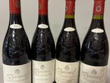 four bottles of wine are lined up on a table