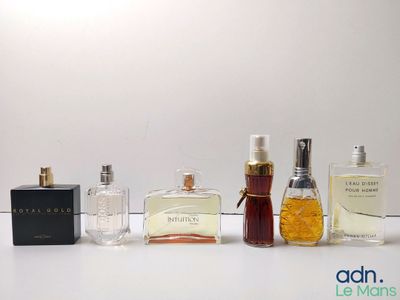 several different types of perfume bottles lined up on a white surface