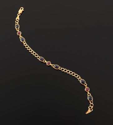 a gold bracelet with multi colored stones on a black background
