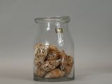 a glass jar filled with nuts on a white surface