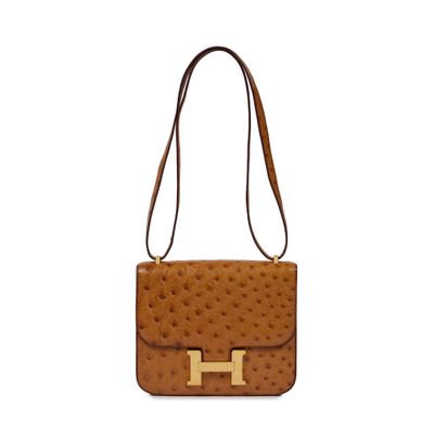 a brown ostrich bag with a gold h on the front