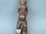 une image représentant une figurine en bois avec une étiquette sur la poitrine