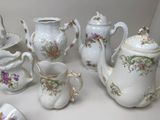 many different types of teapots and saucers on the table