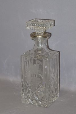 une bouteille en verre transparent munie d'un bouchon argenté