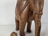 a wooden elephant and a baby elephant standing next to each other