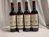 trois bouteilles de vin rouge sont alignées sur une table
