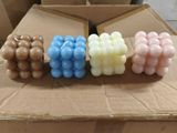 quatre bougies de couleurs différentes posées sur une boîte en carton