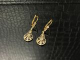 une paire de boucles d'oreilles en or sur une surface noire