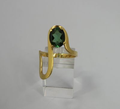 a close up of a ring with a green stone in it