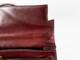 a brown purse with a gold lock on top of it