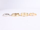 five gold and silver rings sitting on top of a white surface