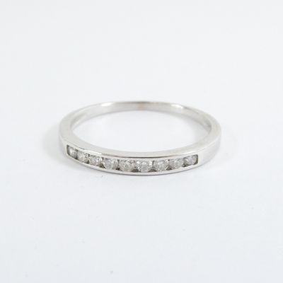 a close up of a diamond ring on a white surface