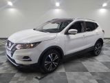 the white nissan suv is parked in a large room