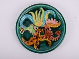a green plate with a picture of a bird and a lizard on it