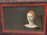 painting of a woman with a red hair in a black frame