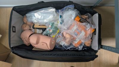 une valise remplie d'objets posée par terre