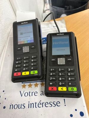 two cell phones sitting on top of a table next to each other