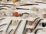 many different types of smoking pipes and pipes on the table