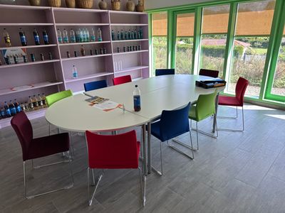 brightly colored chairs sit around a white table in a room with a large window