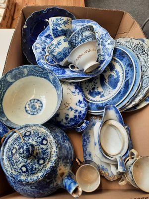 une boîte remplie d'assiettes et de tasses bleues et blanches