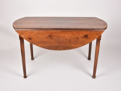 Table ronde à volets en bois naturel. XIXème siècle (fentes …