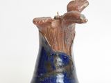 a blue vase with a bird on it on a white surface