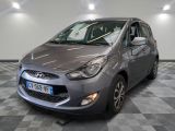 La voiture grise est garée sur le sol à damier du garage.