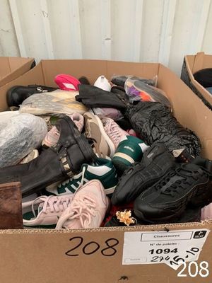 plusieurs paires de chaussures dans une boîte posée sur le sol