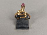 un gros plan d'une bague en or sertie d'une pierre rose