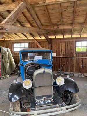 une vieille voiture qui prend la poussière dans un garage