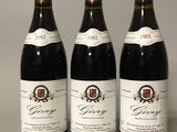 three bottles of red wine are lined up on a table