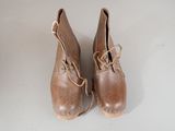 pair of brown leather shoes with laces on them sitting on a white surface