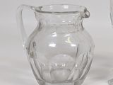 a glass pitcher and a wine glass sitting on a table