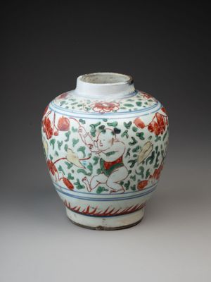 a white vase with red and green designs on it
